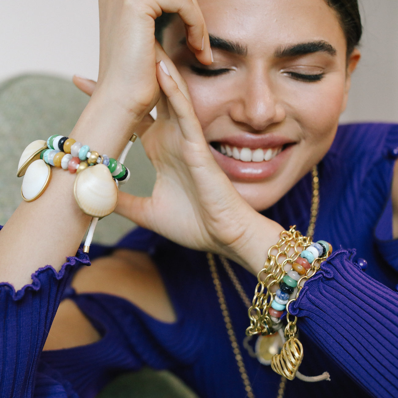 woman in blue shirt with styled jewelry, beads, gold